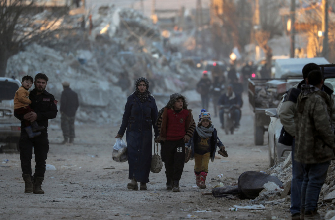 Người dân đi qua các tòa nhà bị tàn phá bởi động đất ở thị trấn Jandaris, Syria, ngày 9/2. Ảnh: Reuters