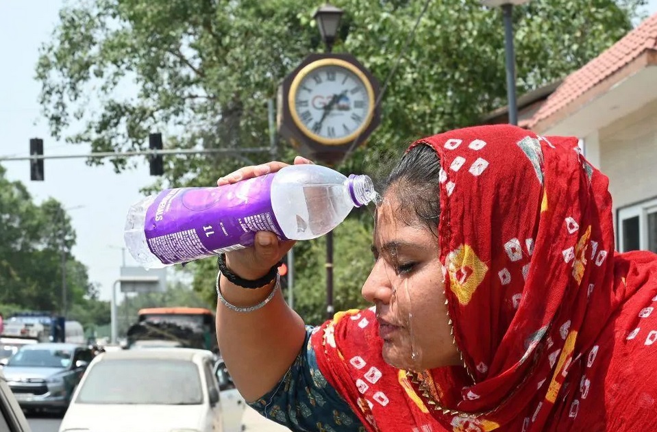 Một cô gái dội nước lên mặt để hạ nhiệt ở New Delhi. Ảnh: Getty Images